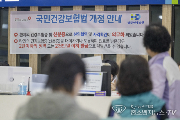 의료기관에서 건강보험이 적용되는 진료를 받을 때 반드시 신분증을 확인해야 하는 ‘요양기관 본인확인 강화 제도’ 국민건강보험법 개정에 대한 안내문을 응시하고 있는 환자들 