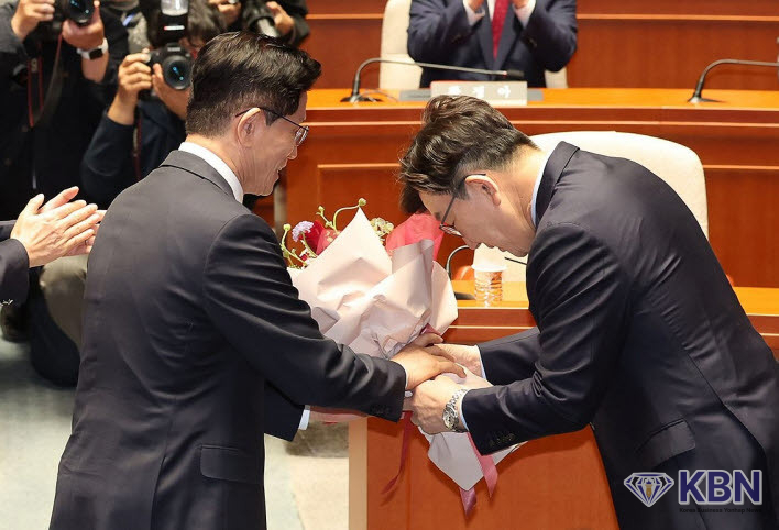 국민의힘 김문수 대선 후보가 9일 서울 여의도 국회에서 열린 의원총회에서 권성동 원내대표로부터 꽃다발을 받고 있다.