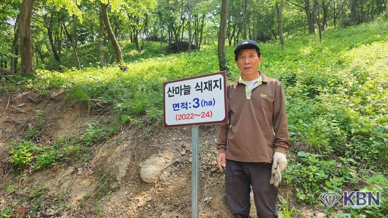 강창원씨가 본인 산마늘 농장에서 포즈를 취하며 명이나물에 대해 간략히 설명하고 있다 ,강씨는 연간 약 7천만원의 수익을 올리고 있으며 무농약,무비료 친환경 산마늘로 소비자들의 건강과 안전한 먹거리를 제공하고 있다