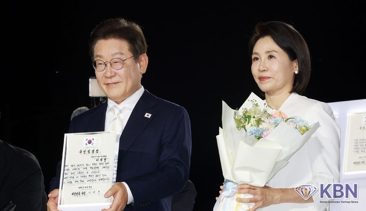 이재명 대통령이 15일 서울 세종대로 광화문광장에서 열린 제21대 대통령 국민임명식 '광복 80년, 국민주권으로 미래를 세우다' 행사에서 임명장을 들어 보이고 있다.